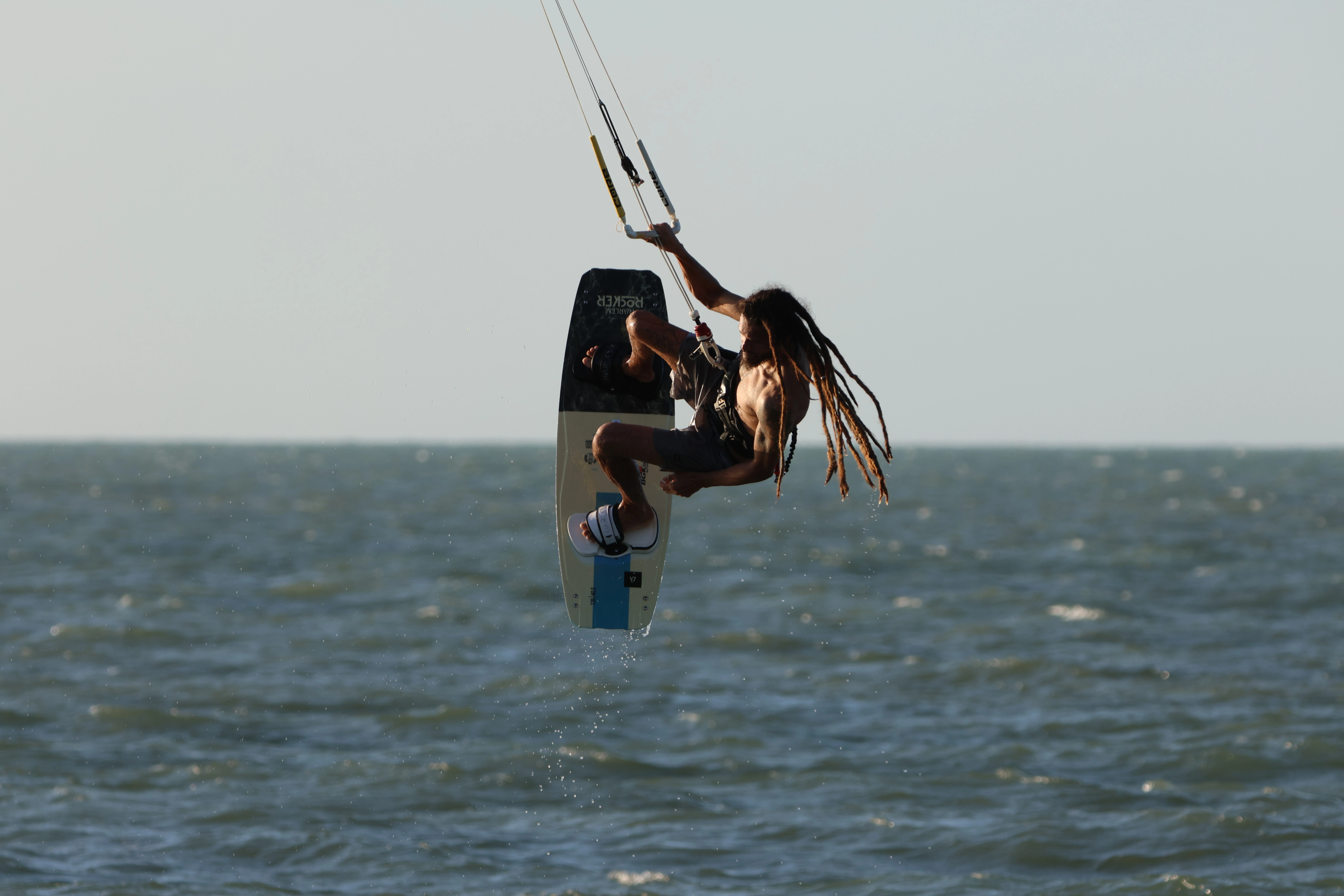 Kitesurfista saltando sobre o mar de Barra Grande com o céu alaranjado ao fundo